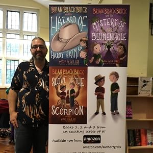 G R Dix at a guest author event, next to a Brian Brackbrick display of the first three books in the series